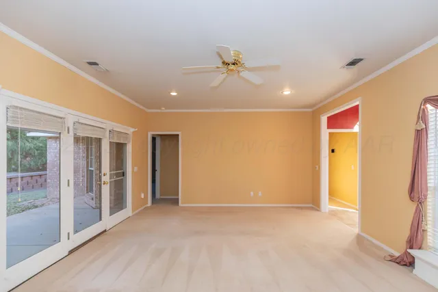 a view of a livingroom with a chandelier fan and windows