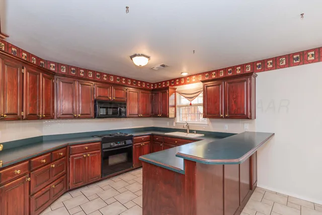 a kitchen with stainless steel appliances granite countertop a sink a stove and a refrigerator