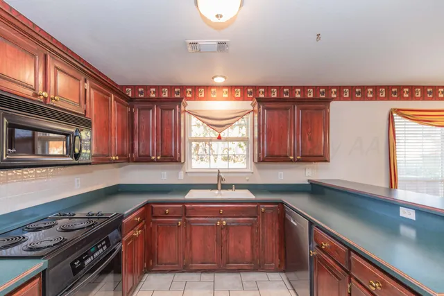 a kitchen with stainless steel appliances granite countertop a sink a stove and a microwave