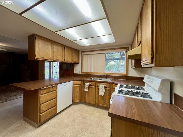 a kitchen with kitchen island granite countertop wooden cabinets stove and refrigerator