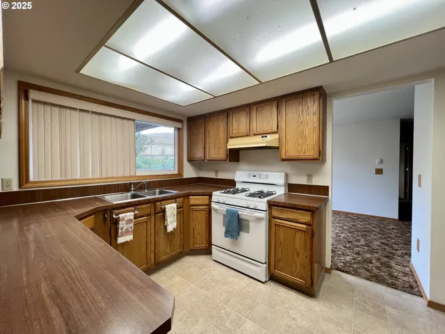 a kitchen with stainless steel appliances granite countertop a stove a sink and a microwave