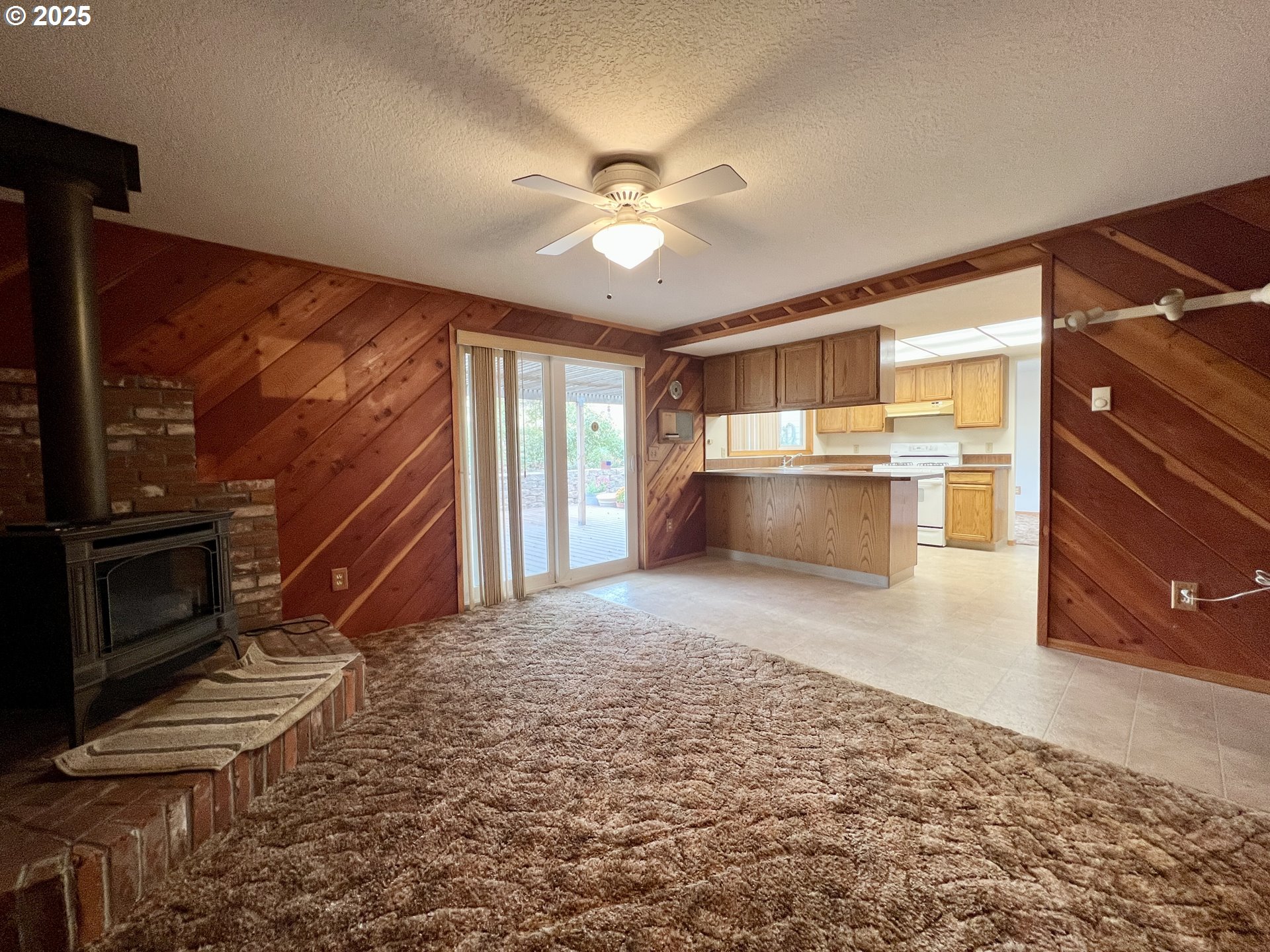 185 Rock Street Heppner, OR 97836 - Photo 19 of 25 a view of a kitchen with a stove cabinets a ceiling fan and wooden floor