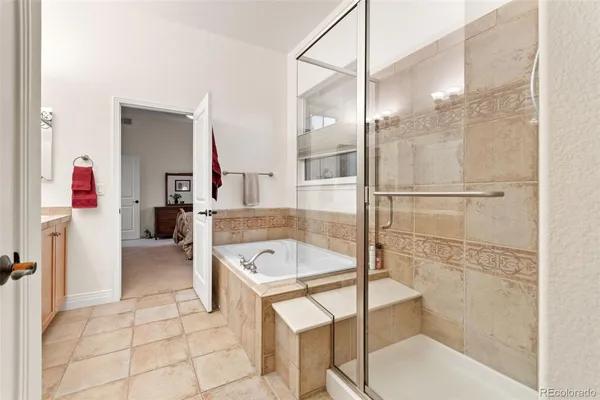 a bathroom with a tub a sink a mirror and a shower
