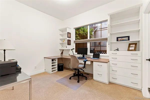 a view of a workspace with furniture and a window