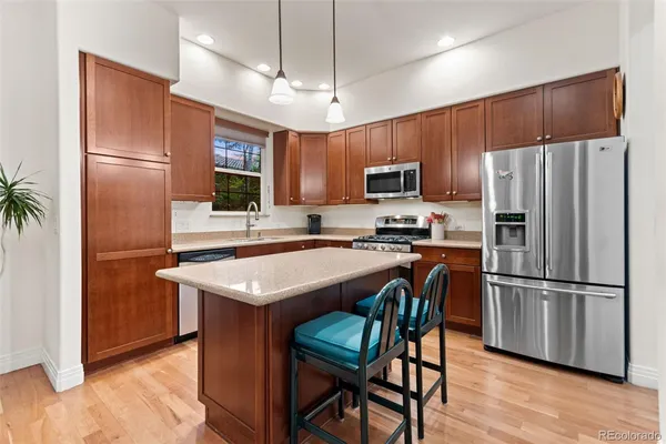 a kitchen with kitchen island a refrigerator stove microwave and sink