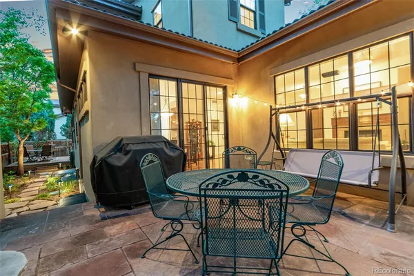 a view of a patio with table and chairs and potted plants