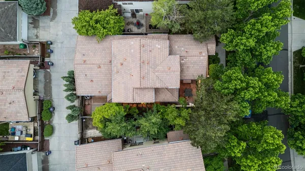 an aerial view of a house with a yard and large trees