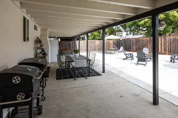 a view of a patio with table and chairs potted plants with wooden floor and fence