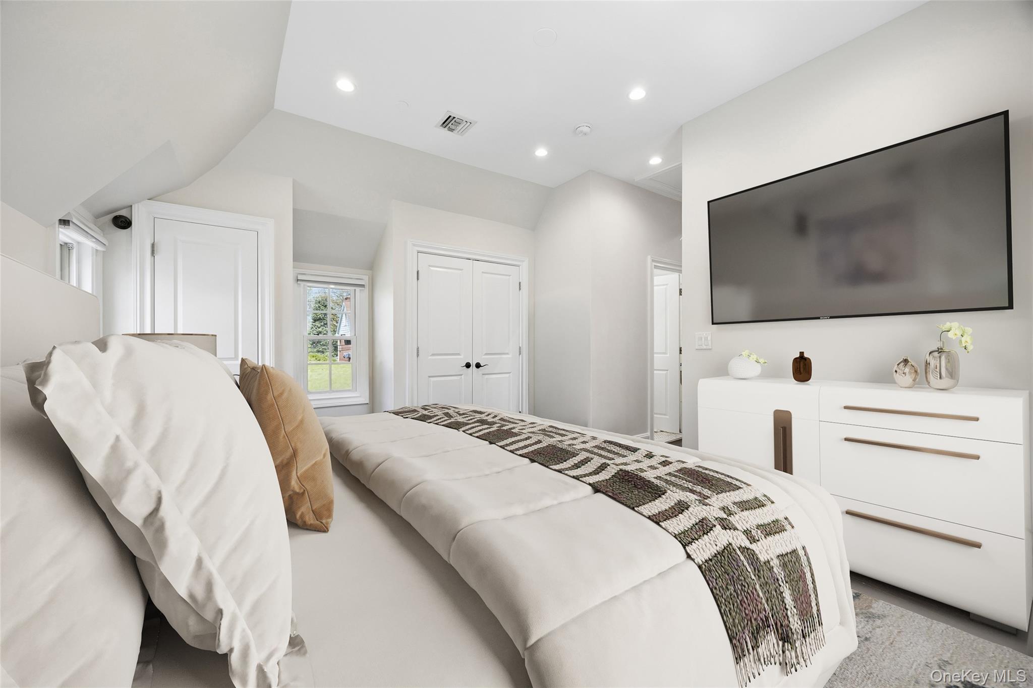 216 Beverly Road Queens, NY 11363 - Photo 18 of 50 a spacious bedroom with a bed and a flat screen tv