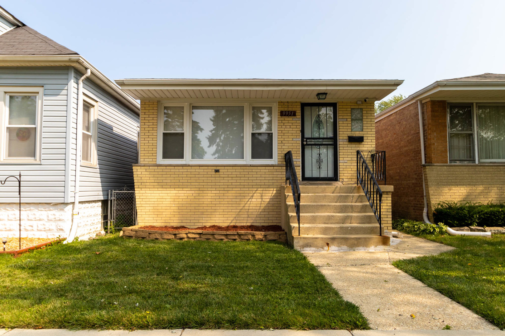 9951 South Perry Avenue Chicago, IL 60628 - Photo 1 of 27 a front view of a house with garden