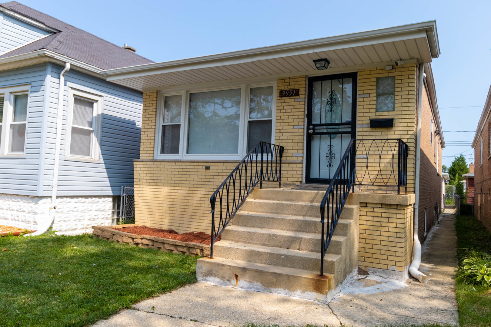 9951 South Perry Avenue Chicago, IL 60628 - Photo 2 of 27 a front view of a house with a garden