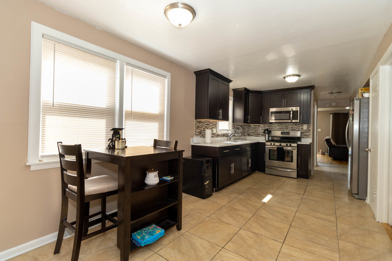 9951 South Perry Avenue Chicago, IL 60628 - Photo 13 of 27 a kitchen with a sink refrigerator and cabinets