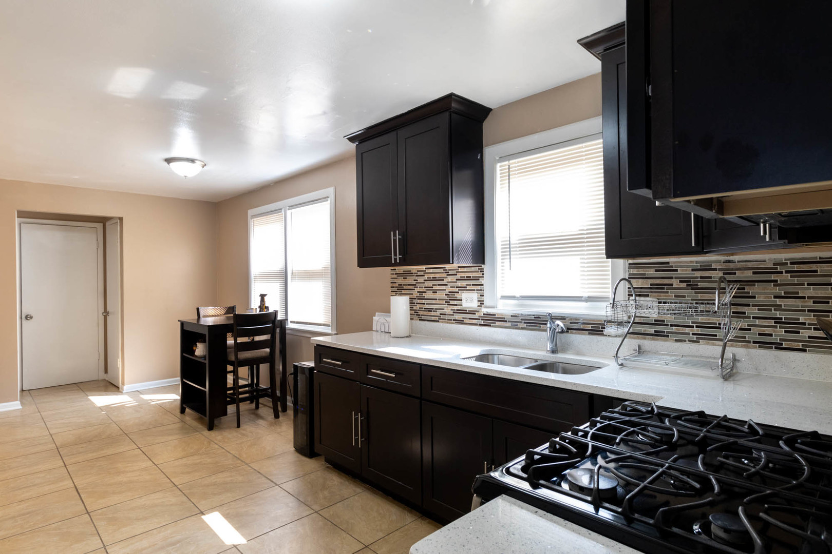 9951 South Perry Avenue Chicago, IL 60628 - Photo 15 of 27 a kitchen with a sink stove and cabinets
