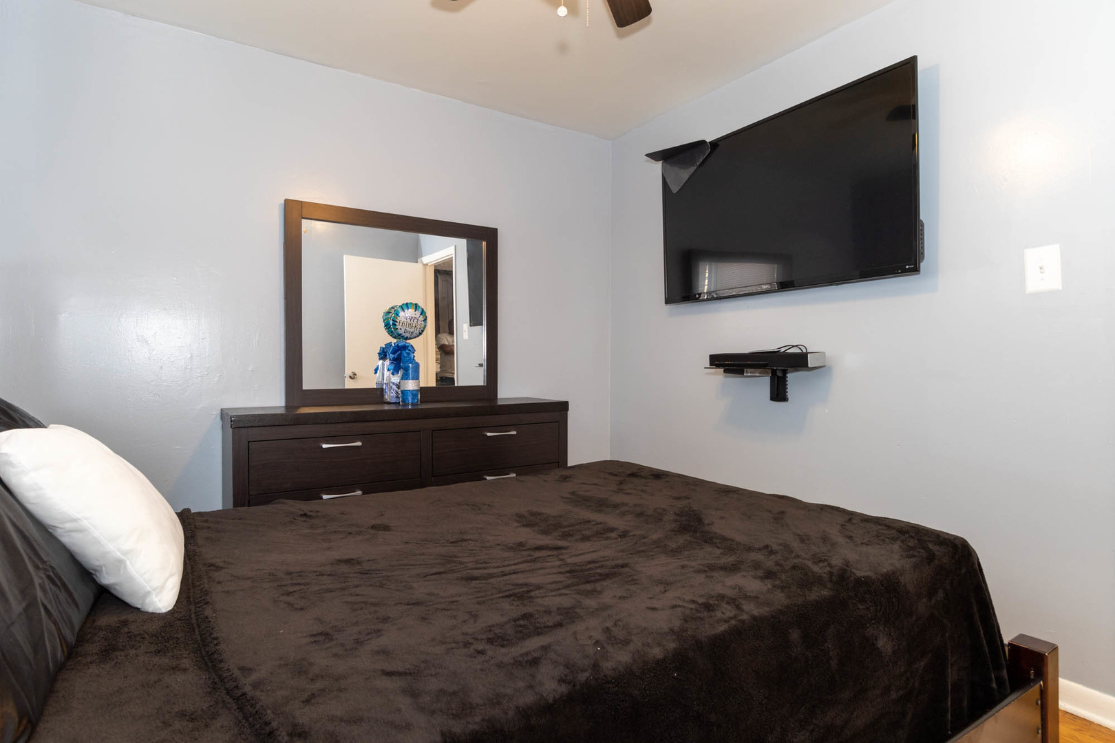 9951 South Perry Avenue Chicago, IL 60628 - Photo 17 of 27 a bedroom with a bed and a flat screen tv