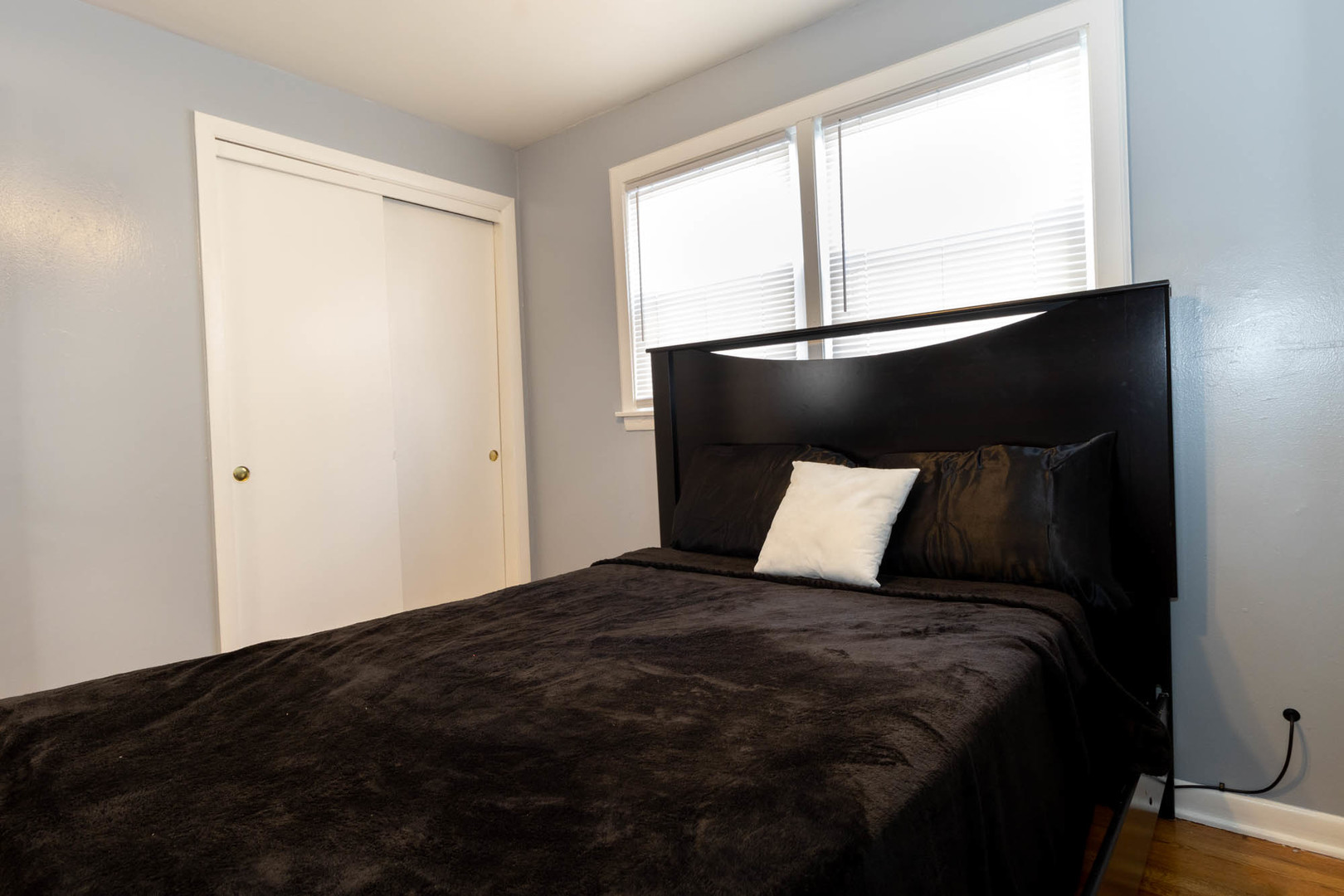 9951 South Perry Avenue Chicago, IL 60628 - Photo 18 of 27 a bed sitting in a bedroom next to a window