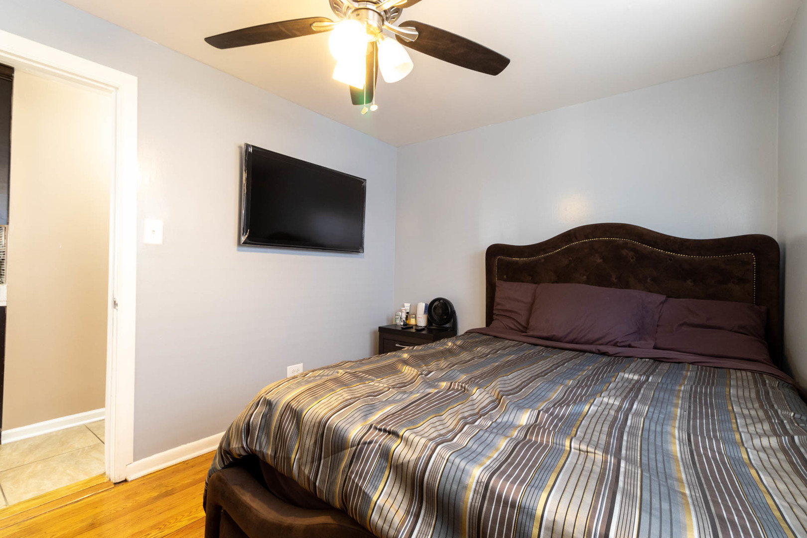 9951 South Perry Avenue Chicago, IL 60628 - Photo 10 of 27 a bedroom with a large bed and a flat screen tv