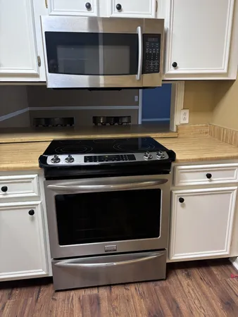 a stove top oven sitting inside of a kitchen