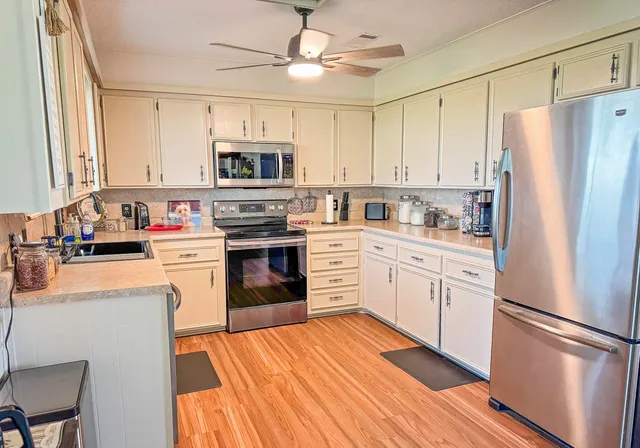 a kitchen with stainless steel appliances a stove a sink and a refrigerator
