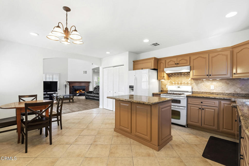 2546 Commerce Way Commerce, CA 90040 - Photo 8 of 53 a kitchen with stainless steel appliances granite countertop a table and chairs in it