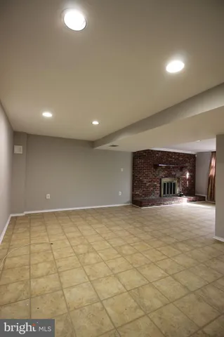 a view of an empty room with fireplace and a window