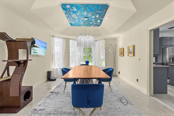 a bedroom with a large bed chandelier and a window
