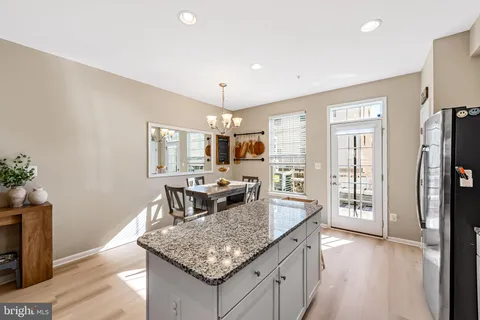 a kitchen with stainless steel appliances granite countertop sink stove refrigerator and wooden floor