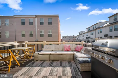 a balcony with wooden floor table and chairs