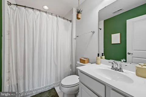 a bathroom with a sink a toilet and shower curtain