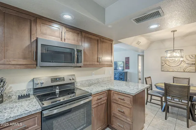 a kitchen with stainless steel appliances granite countertop a stove microwave and sink