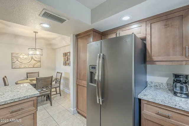 a kitchen with granite countertop a refrigerator and microwave