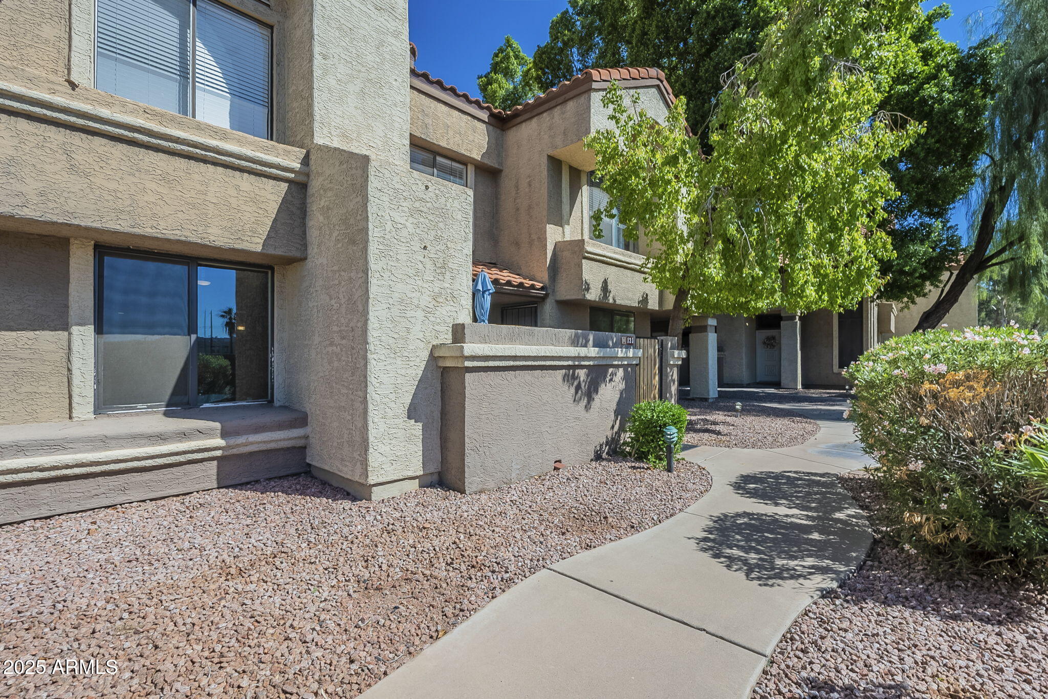1905 East University Drive, Unit 131 Tempe, AZ 85288 - Photo 2 of 36 a view of a house with a yard and plants