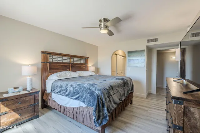 a bedroom with a bed and wooden floor