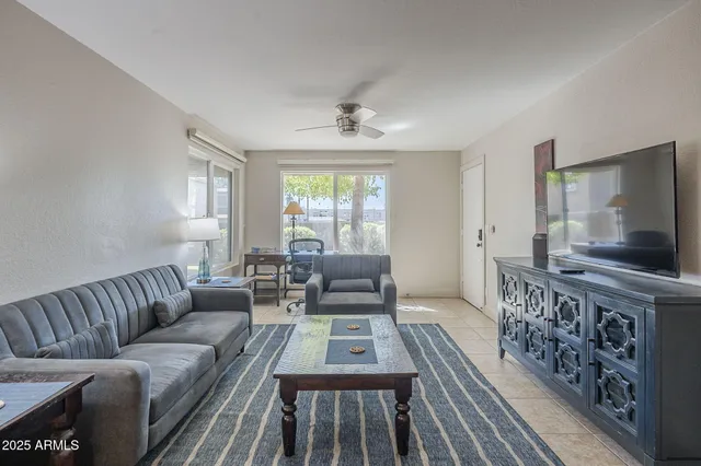 a living room with furniture a flat screen tv and a window