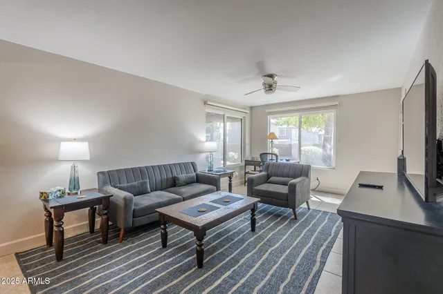 a living room with furniture a rug and a window