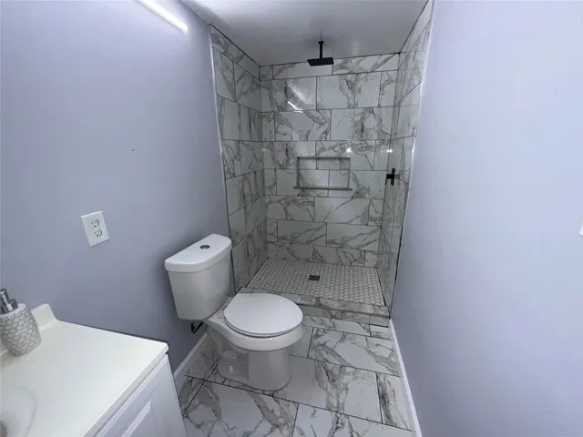 a bathroom with a toilet and a shower