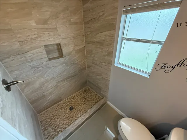 a bathroom with a toilet and a shower