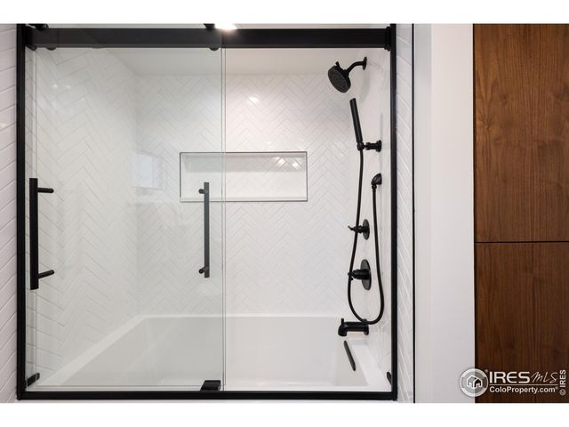 a bathroom with a granite countertop sink a shower and mirror