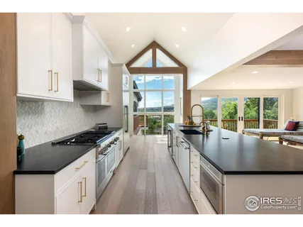 a white kitchen with granite countertop a sink and a granite counter tops