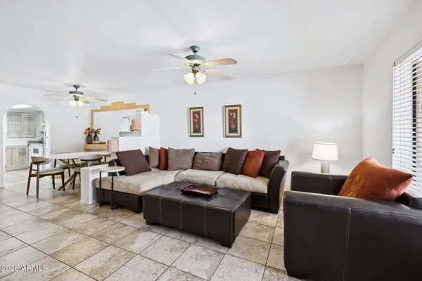 a living room with furniture a chandelier and a window