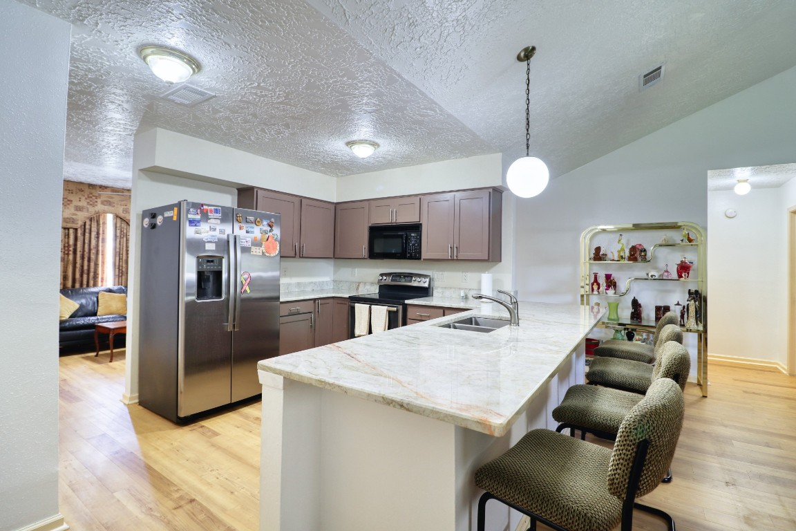 3446 Cheaney Drive Houston, TX 77066 - Photo 15 of 49 a kitchen with stainless steel appliances kitchen island granite countertop a refrigerator a stove top oven a sink dishwasher and a dining table with wooden floor