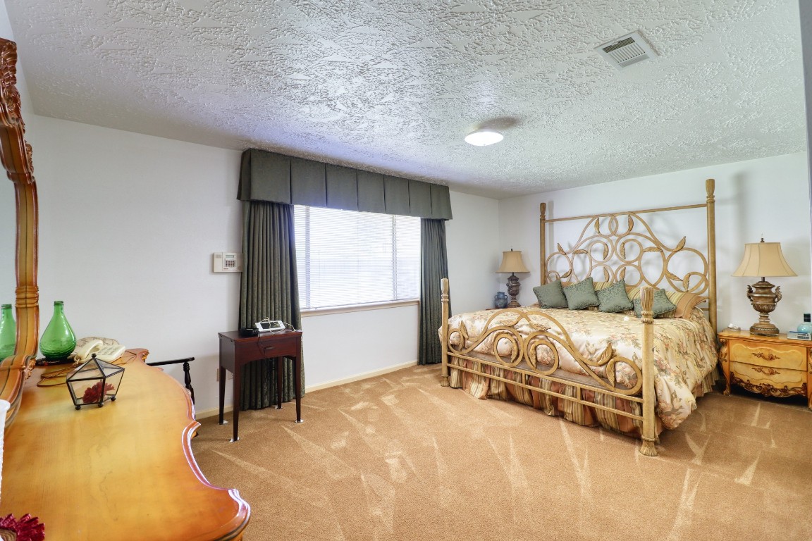 3446 Cheaney Drive Houston, TX 77066 - Photo 24 of 49 a spacious bedroom with a bed and a flat tv screen