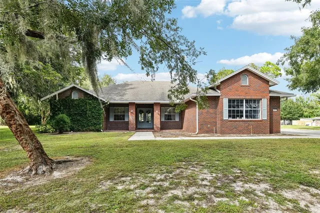 a front view of a house with a yard and trees