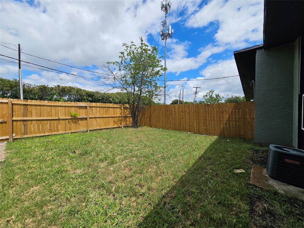 1725 R Avenue, Unit 1725 Plano, TX 75074 - Photo 18 of 20 Private backyard space featuring a wooden privacy fence, a mature tree, and a grass lawn