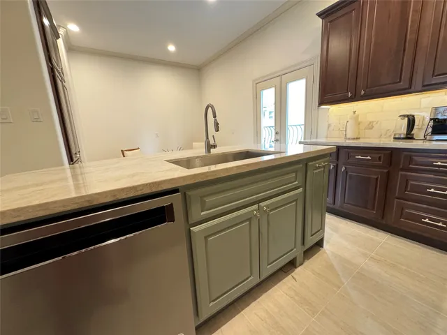 a kitchen with granite countertop a stove top oven cabinetry a sink and a counter