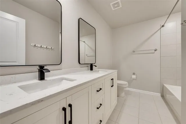 a bathroom with double sink and a mirror