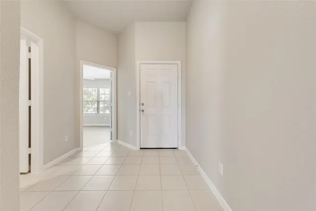 a view of an empty room with closet and a window