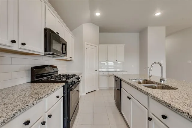 a kitchen with stainless steel appliances granite countertop a sink stove microwave and cabinets