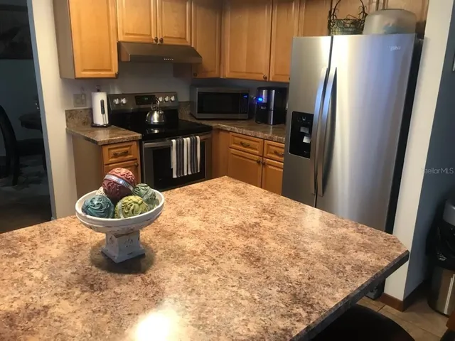 a kitchen with a refrigerator and a stove