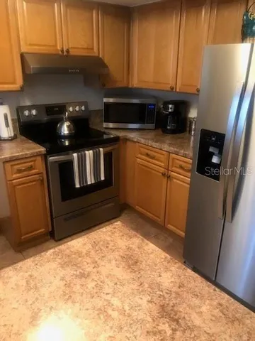 a kitchen with stainless steel appliances granite countertop a stove a sink and a microwave