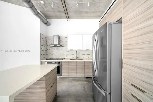 a kitchen with a refrigerator and white cabinets